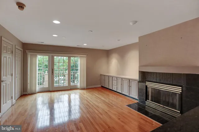 a view of empty room with wooden floor and fireplace