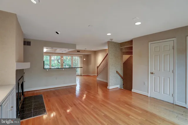 a view of front door with wooden floor and fence