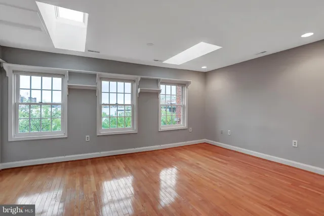 a view of an empty room with wooden floor