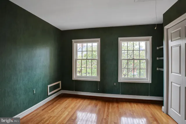 an empty room with wooden floor and closet