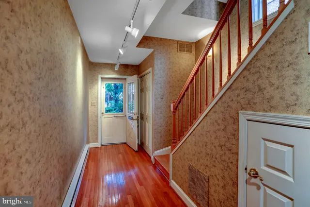 a view of entryway and hall with wooden floor