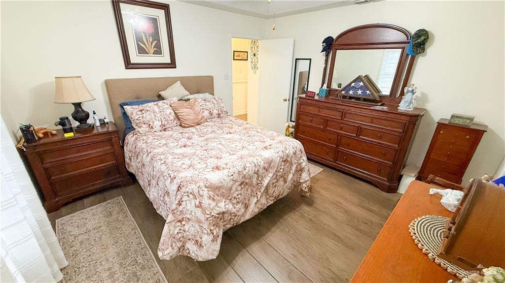 518 Taurus Street Mission, TX 78572 - Photo 11 of 20 a bed sitting in a bedroom next to a wooden floor
