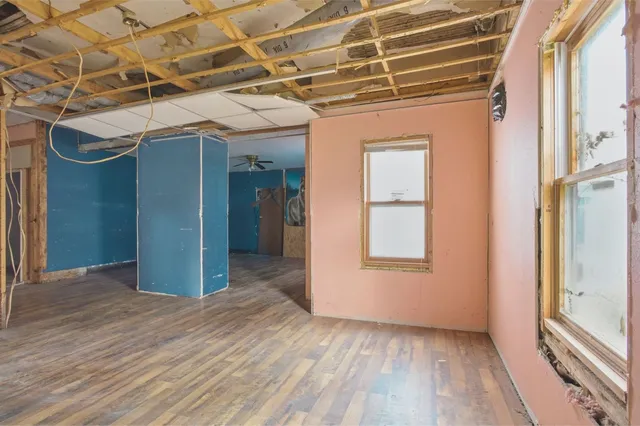a view of a livingroom with wooden floor and ceiling fan