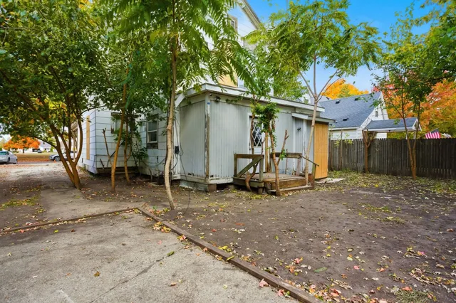 a white house that has a tree in front of it