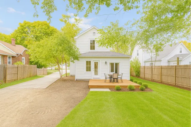 a view of a house with backyard and sitting area
