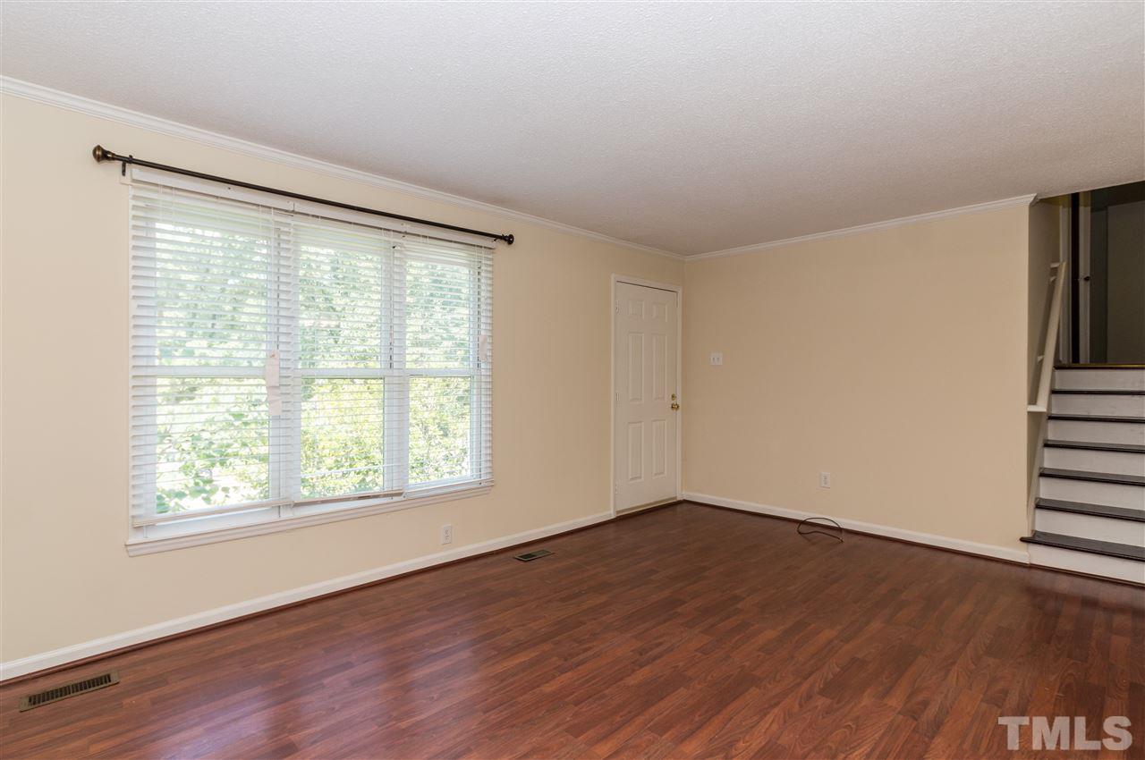 6812 Glendower Road Raleigh, NC 27613 - Photo 3 of 23 an empty room with wooden floor and windows