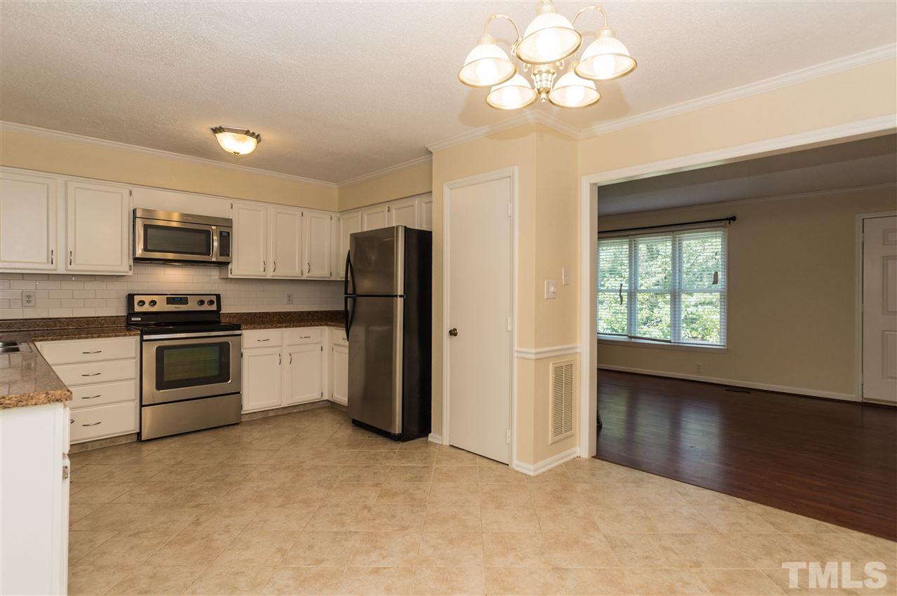 6812 Glendower Road Raleigh, NC 27613 - Photo 6 of 23 a kitchen with a refrigerator and a stove top oven