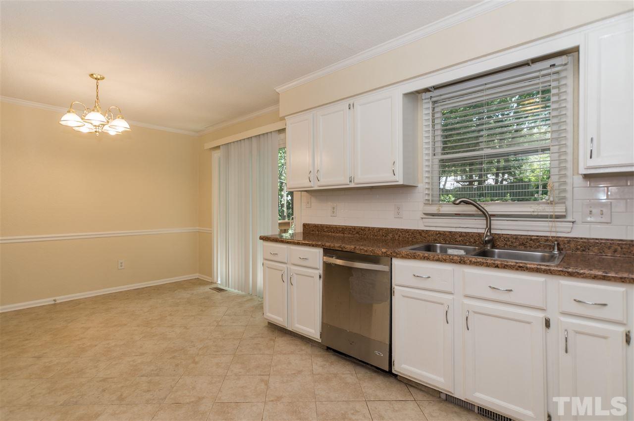 6812 Glendower Road Raleigh, NC 27613 - Photo 8 of 23 a kitchen with granite countertop white cabinets and a window