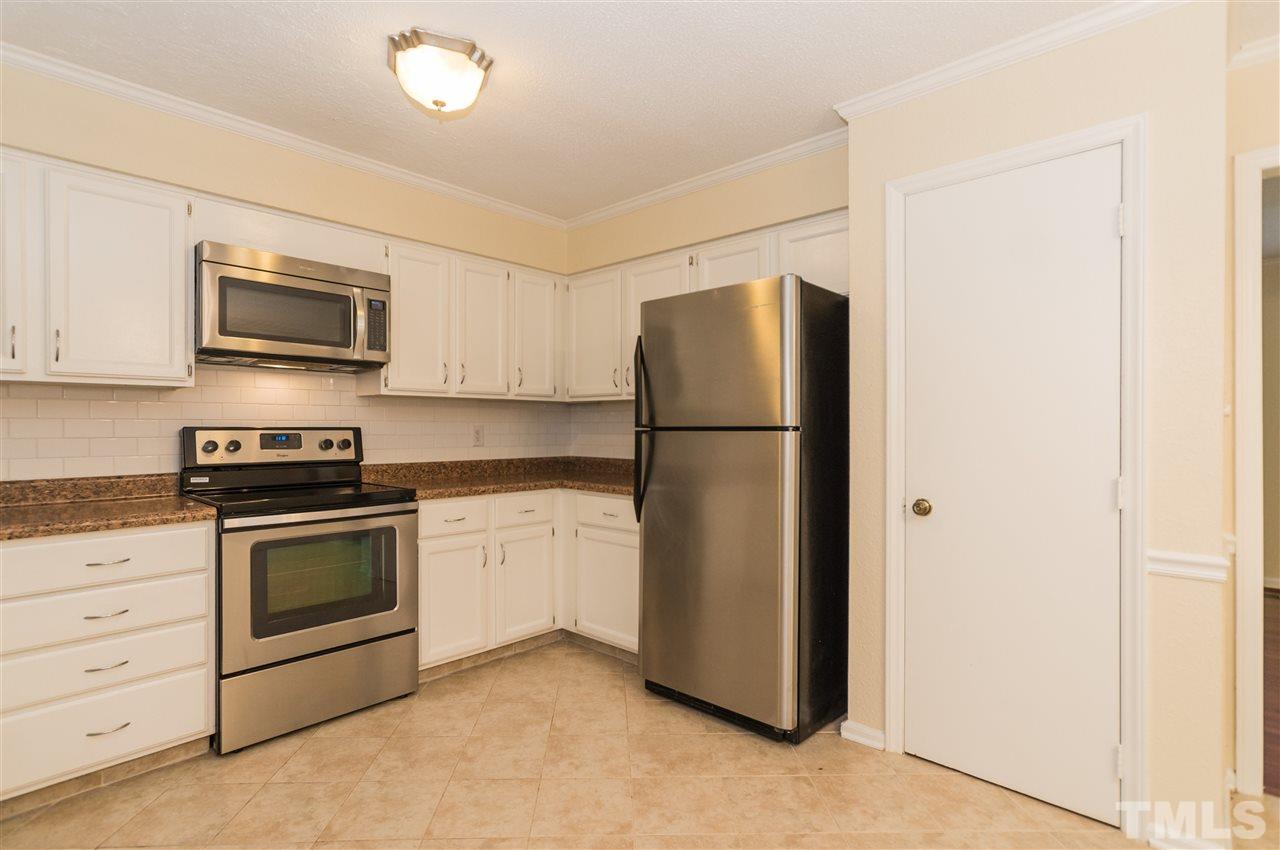 6812 Glendower Road Raleigh, NC 27613 - Photo 9 of 23 a kitchen with a refrigerator stove and microwave
