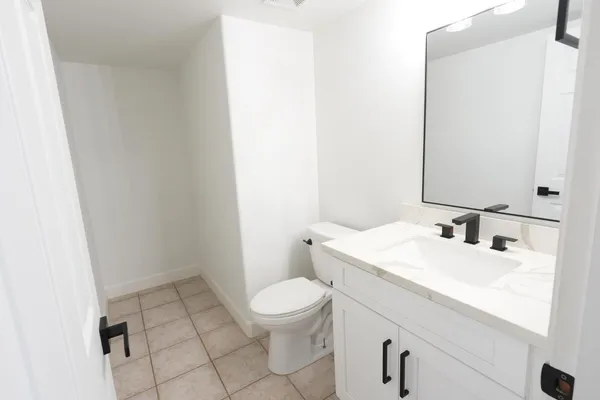 a bathroom with a sink a toilet and a mirror
