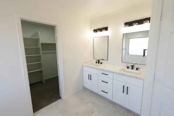 a bathroom with a double vanity sink and mirror