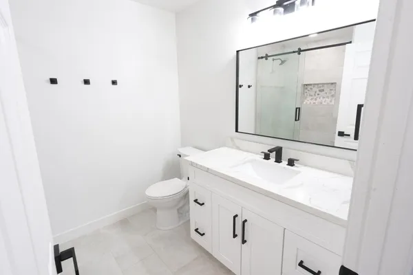 a bathroom with a toilet sink and mirror