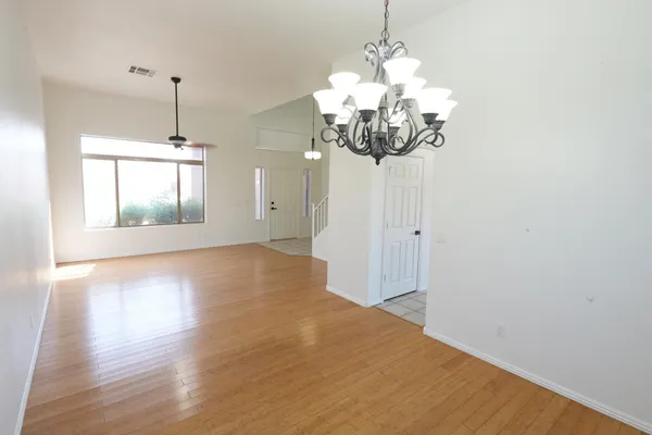 a view of a room with chandelier and wooden floor
