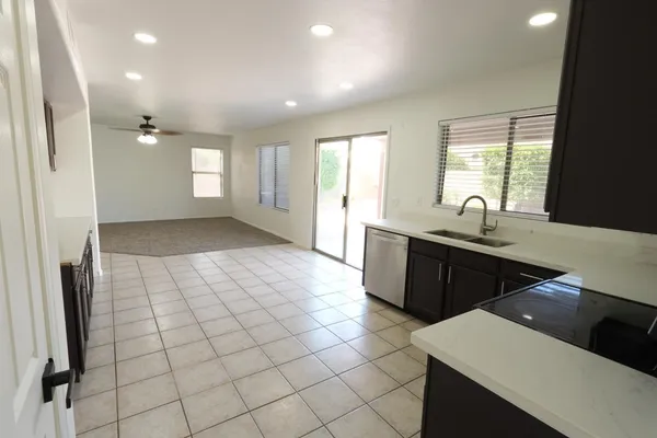 a large white kitchen with a sink a counter space and a window