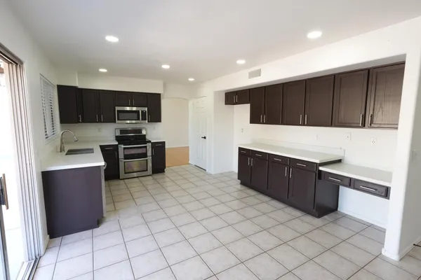 a large kitchen with stainless steel appliances granite countertop a refrigerator and a stove top oven