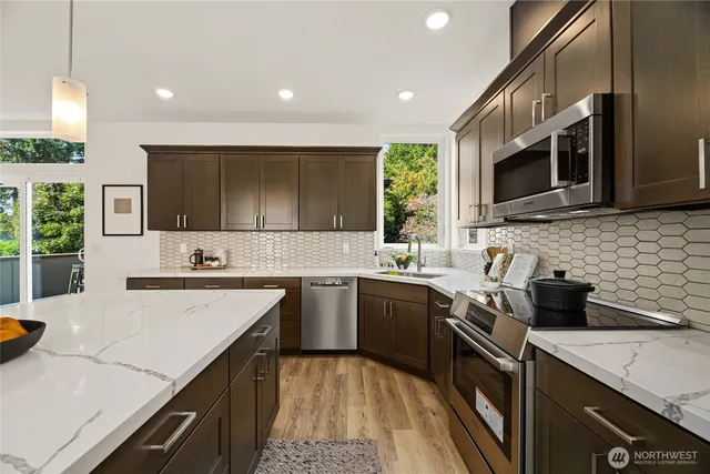 a kitchen with a sink stove top oven and microwave