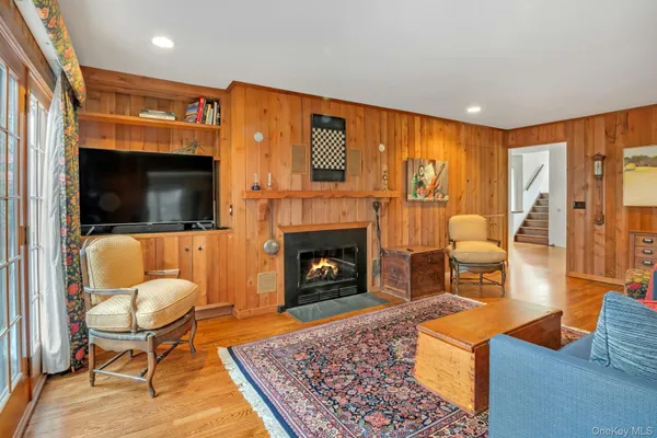 a living room with furniture a rug a fireplace and a flat screen tv