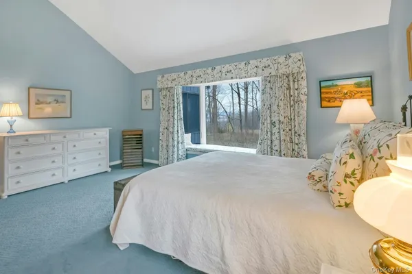 a spacious bedroom with a bed and a dresser