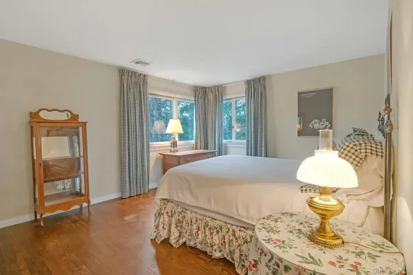 a bedroom with a bed and dresser with mirror