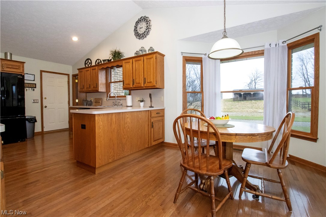 8084 Millbrook Road Shreve, OH 44676 - Photo 5 of 35 Kitchen featuring vaulted ceiling, black fridge, light wood-type flooring, and pendant lighting