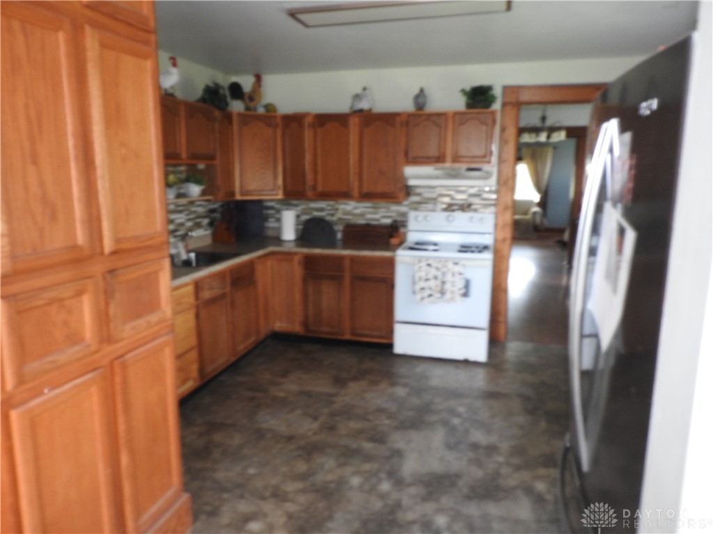2105 East Loy Road Piqua, OH 45356 - Photo 11 of 26 This spacious kitchen offers ample cabinetry and practical appliances, perfect for everyday living.