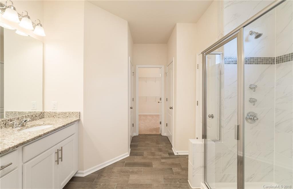 5318 Meadowcroft Way, Unit 62 Fort Mill, SC 29708 - Photo 14 of 19 a bathroom with a granite countertop sink a mirror and a shower