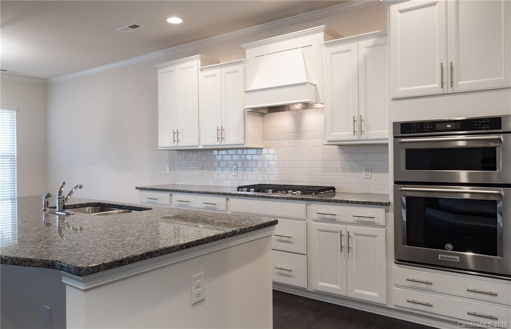 5318 Meadowcroft Way, Unit 62 Fort Mill, SC 29708 - Photo 8 of 19 a kitchen with granite countertop white cabinets and a stove