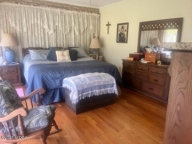 6285 Forsyth Road Macon, GA 31210 - Photo 5 of 24 a bedroom with a bed and wooden floor