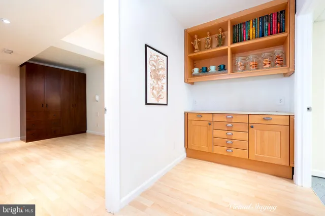 a view of an empty room with cabinet and window