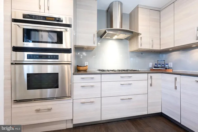 a kitchen with granite countertop white cabinets stainless steel appliances and sink