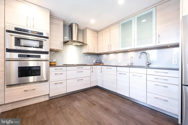 a kitchen with granite countertop white cabinets and stainless steel appliances
