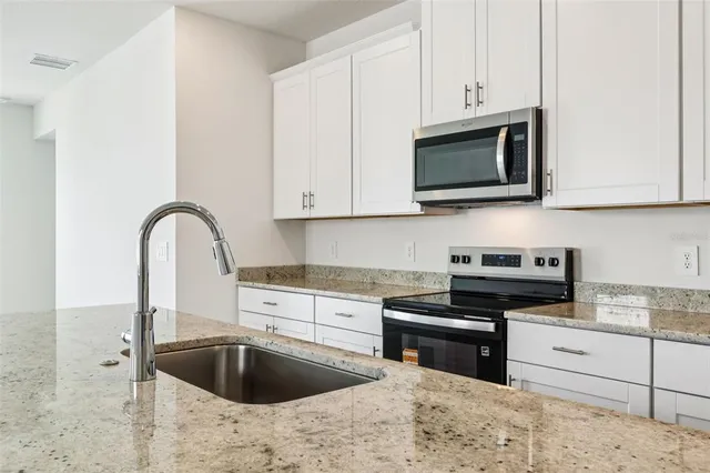 a kitchen with stainless steel appliances granite countertop a sink and a stove