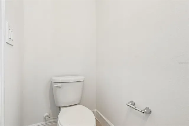 a white toilet sitting next to a white wall