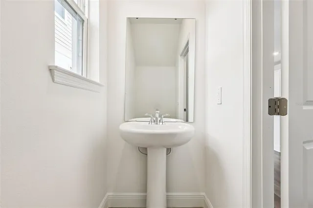 a bathroom with a sink a mirror and a window