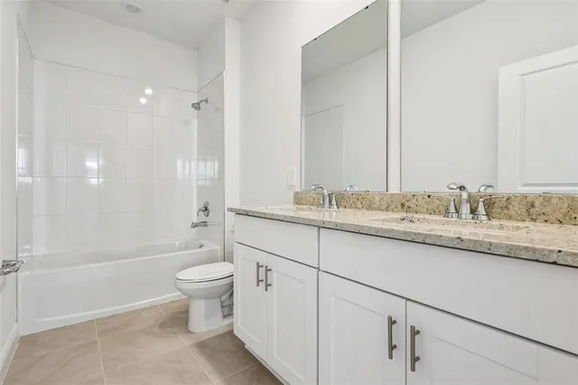 a bathroom with a granite countertop sink a toilet and shower