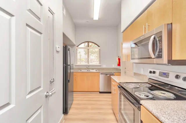 a kitchen with stainless steel appliances granite countertop a stove a sink and a refrigerator