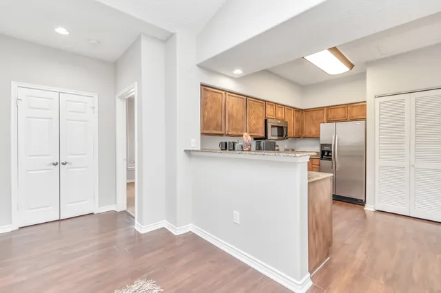 a kitchen with stainless steel appliances granite countertop a refrigerator and a stove top oven