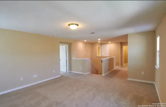 a view of a big room with white walls and windows
