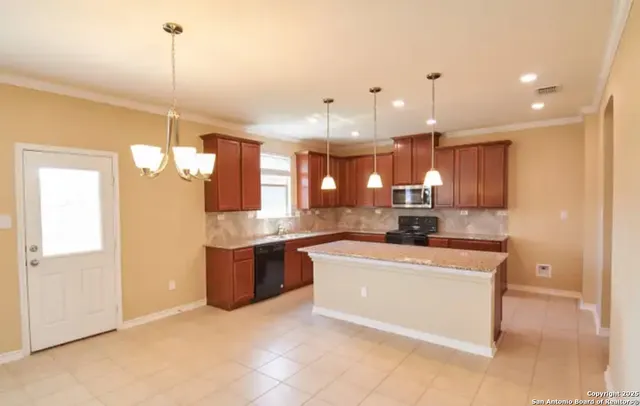 a kitchen with kitchen island a sink a counter top space and stainless steel appliances