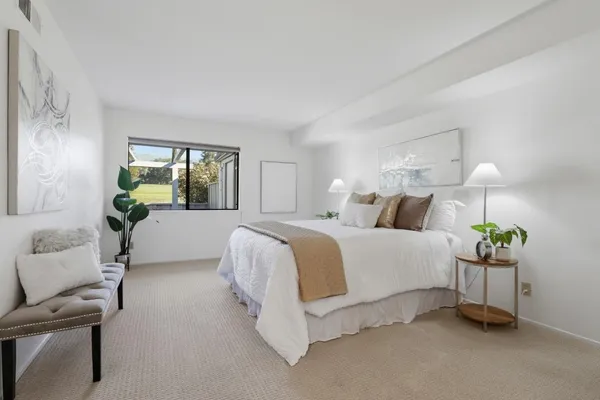 a spacious bedroom with a bed and a chandelier