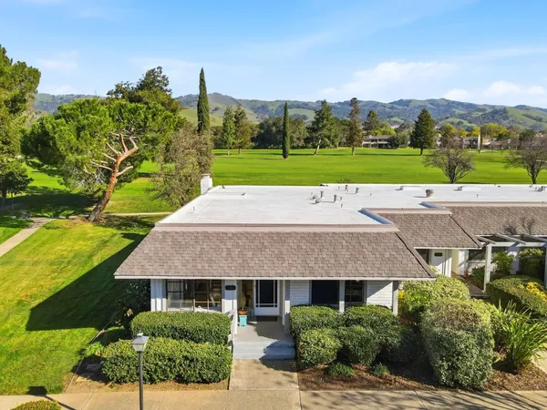 a view of a house with a big yard and large trees