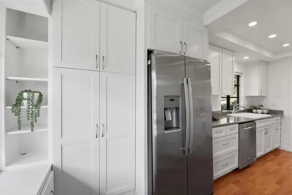 a kitchen with sink a stove and wooden floor
