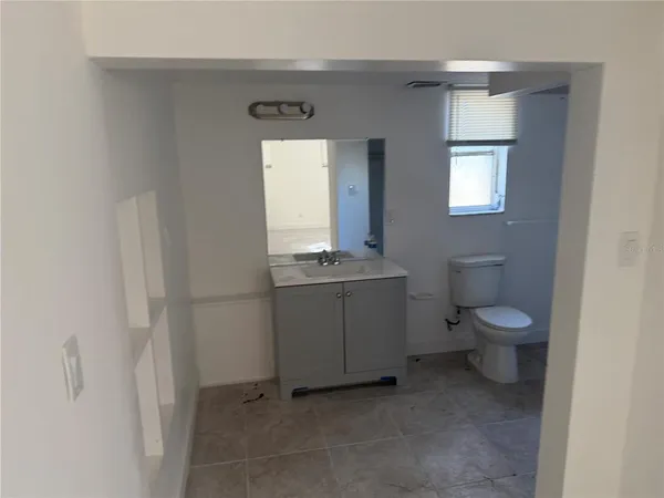 a bathroom with a toilet a sink and mirror