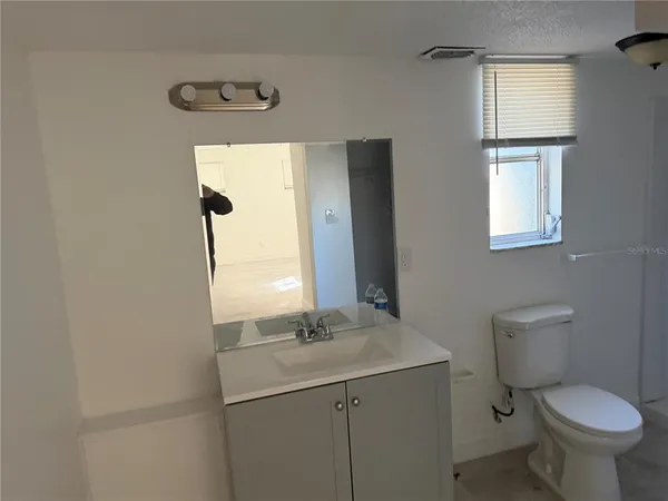 a bathroom with a toilet sink and mirror