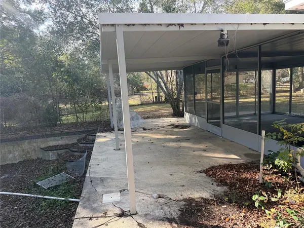 a view of a porch with a floor to ceiling window and a yard
