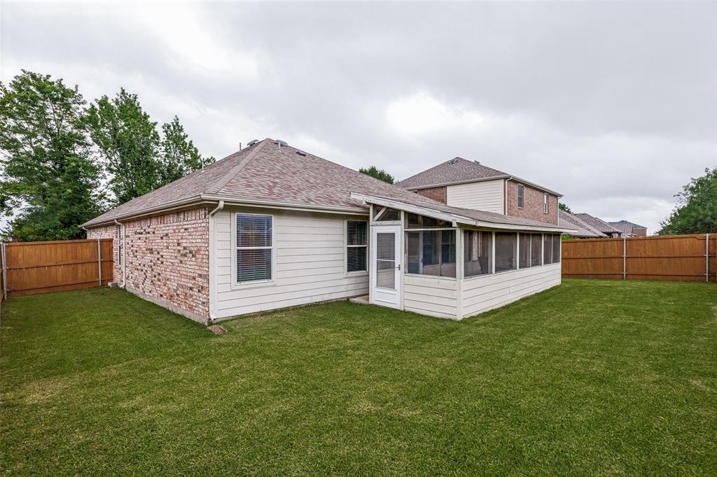 4305 Ridgewood Road Melissa, TX 75454 - Photo 22 of 26 Spacious backyard featuring a screened-in porch, privacy fencing, and a combination of brick and siding exterior