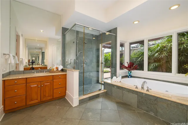 a spacious bathroom with a tub sink and mirror