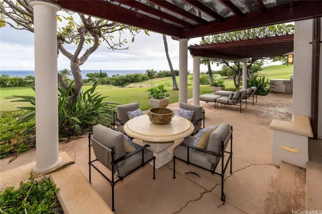 a view of a patio with a table chairs and a floor to ceiling window