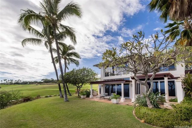 a front view of a building with garden and trees
