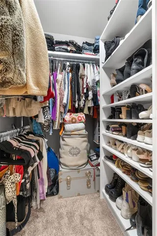 a view of walk in closet with clothes and shoes